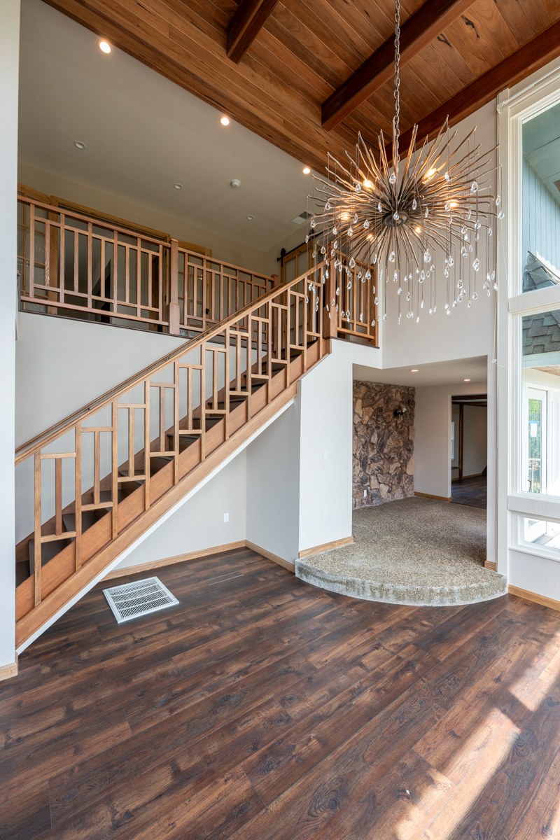Dramatic entry with sputnik chandelier and wood staircase — Poplar fire rebuild